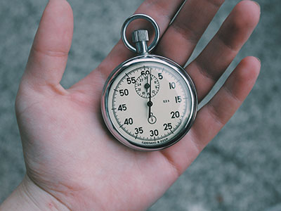 A hand holding a stopwatch