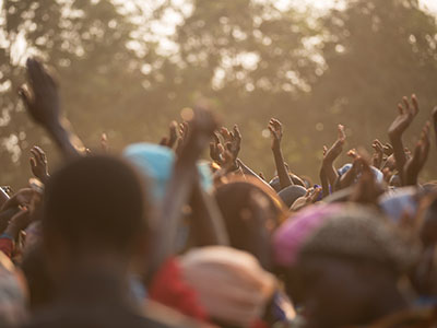 A community in Africa raising their hands in the air