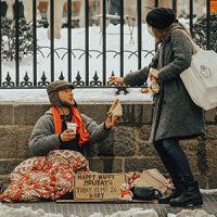 Woman giving food to man on street